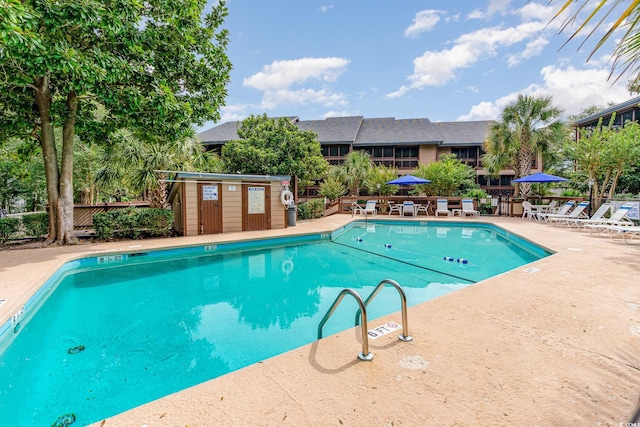 view of swimming pool with an outbuilding and a patio