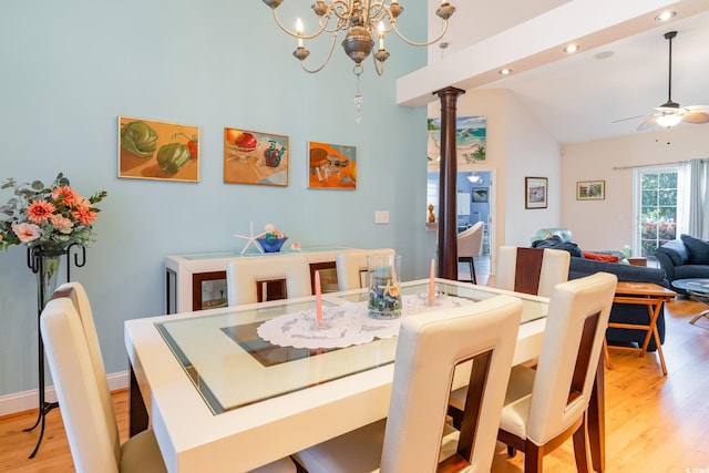 dining space featuring ceiling fan with notable chandelier, light hardwood / wood-style floors, and vaulted ceiling