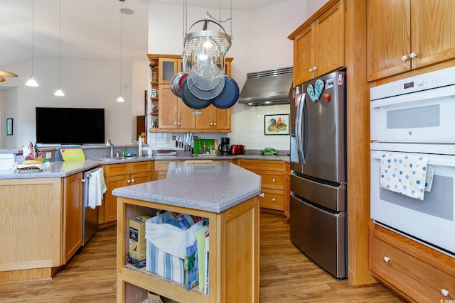 4839 Seabreeze Ln, Myrtle Beach, SC 29579 - kitchen with a peninsula, light wood-style flooring, appliances with stainless steel finishes, a sink, and ventilation hood
