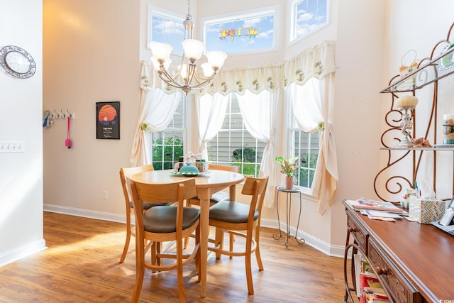 4839 Seabreeze Ln, Myrtle Beach, SC 29579 - dining space featuring baseboards, a high ceiling, an inviting chandelier, and wood finished floors