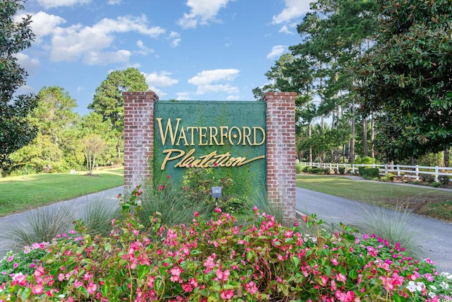 community / neighborhood sign featuring a yard