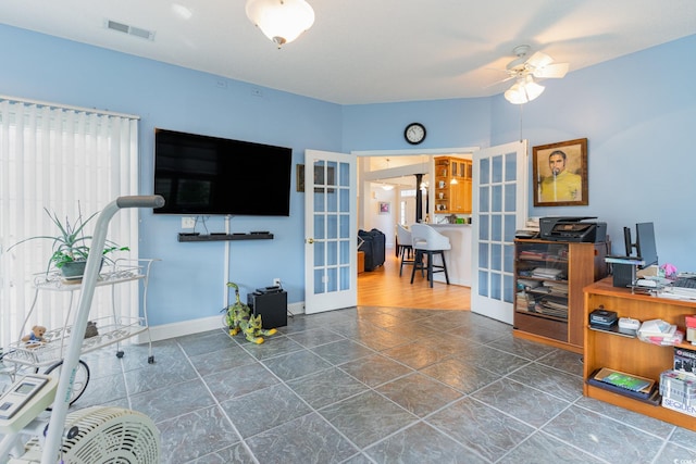 office with ceiling fan and french doors