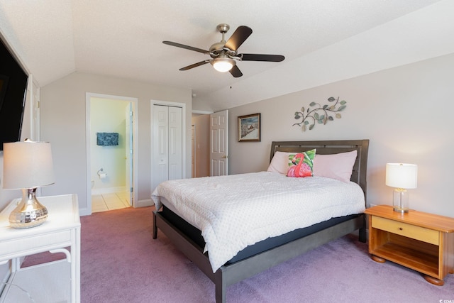 bedroom featuring vaulted ceiling, a closet, ceiling fan, ensuite bathroom, and carpet