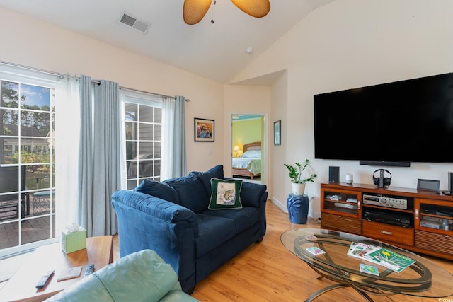 living room featuring lofted ceiling, light hardwood / wood-style floors, and ceiling fan