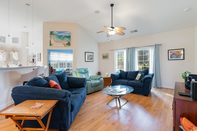 living room featuring ceiling fan, light hardwood / wood-style floors, and vaulted ceiling