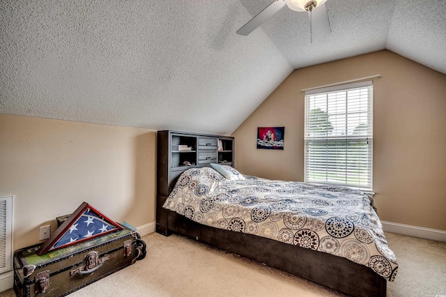 bedroom featuring vaulted ceiling, ceiling fan, carpet floors, and a textured ceiling