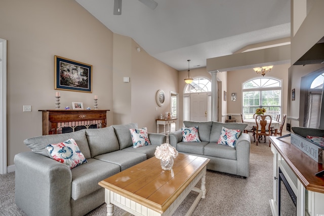 living room with decorative columns, lofted ceiling, ceiling fan with notable chandelier, and light carpet