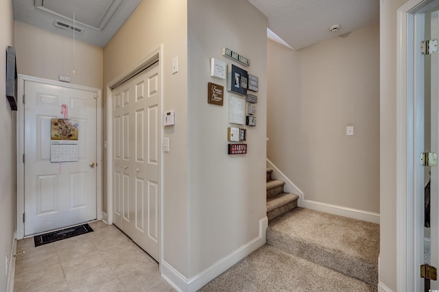 interior space featuring a textured ceiling and light colored carpet