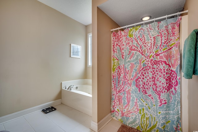 bathroom with a textured ceiling, a bathing tub, and tile patterned floors