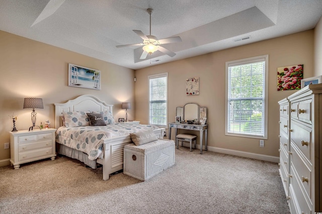 carpeted bedroom with ceiling fan and a textured ceiling