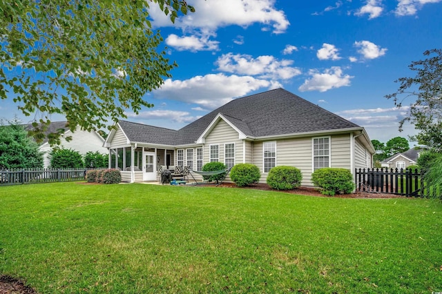 rear view of house featuring a yard and a sunroom