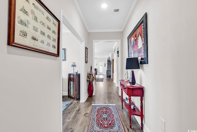 hallway with ornamental molding and light hardwood / wood-style floors