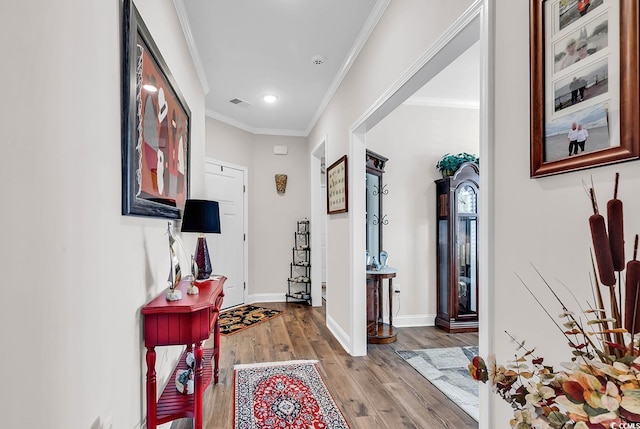 hall featuring light wood-type flooring and crown molding