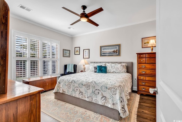 bedroom with ornamental molding, wood-type flooring, and ceiling fan