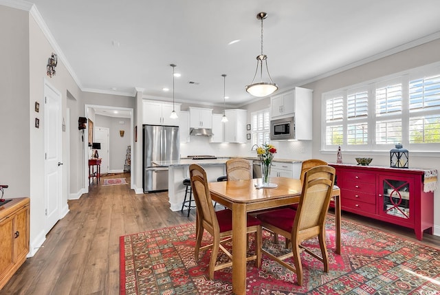 dining room featuring light hardwood / wood-style floors and crown molding