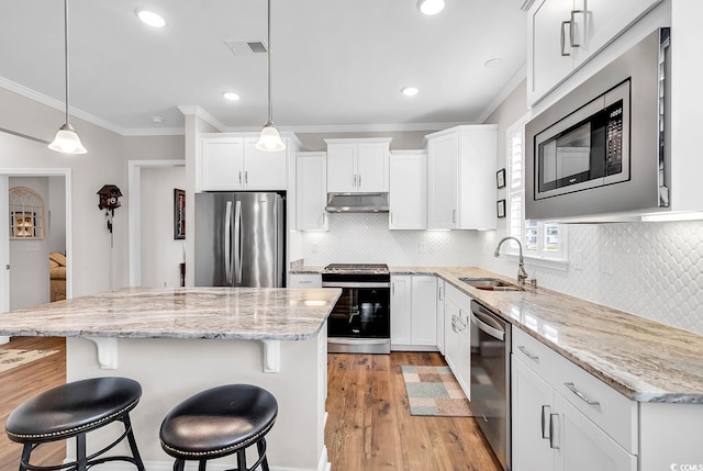 kitchen featuring light hardwood / wood-style floors, a center island, sink, white cabinets, and stainless steel appliances