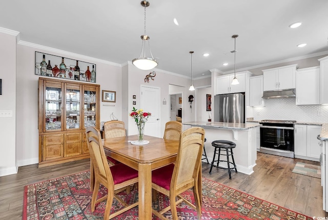 dining area featuring ornamental molding and hardwood / wood-style floors