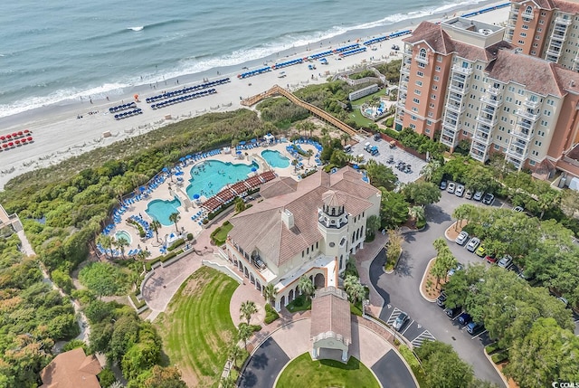 birds eye view of property featuring a water view and a beach view