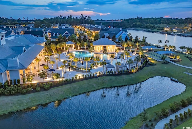 aerial view at dusk featuring a water view