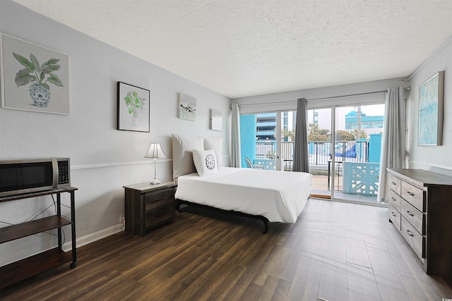 bedroom featuring a textured ceiling, access to exterior, and dark hardwood / wood-style flooring