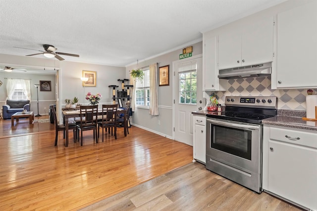 kitchen with light wood-type flooring, stainless steel range with electric cooktop, white cabinetry, backsplash, and ceiling fan