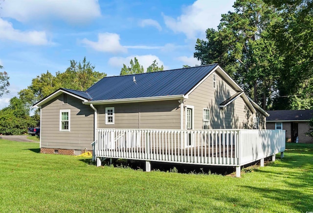 rear view of property featuring a deck and a yard