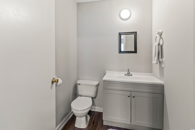 bathroom with hardwood / wood-style floors, vanity, and toilet