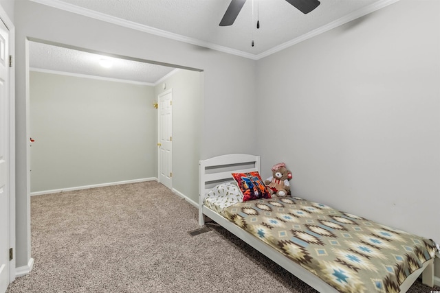 bedroom featuring ceiling fan, ornamental molding, a textured ceiling, and carpet flooring