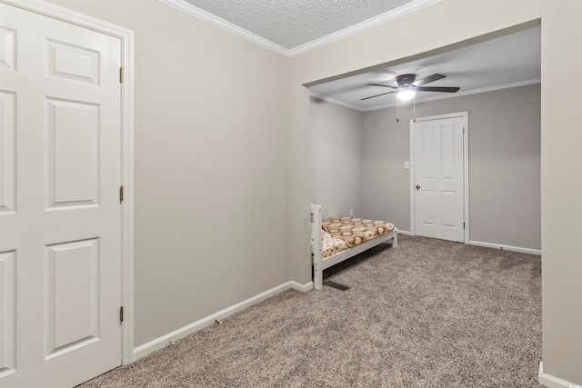 unfurnished room featuring ceiling fan, a textured ceiling, crown molding, and carpet