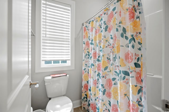 bathroom featuring toilet and a shower with curtain