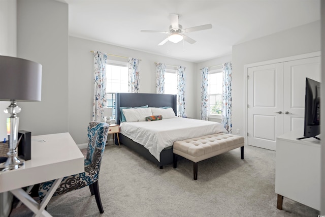 carpeted bedroom with ceiling fan, multiple windows, and a closet