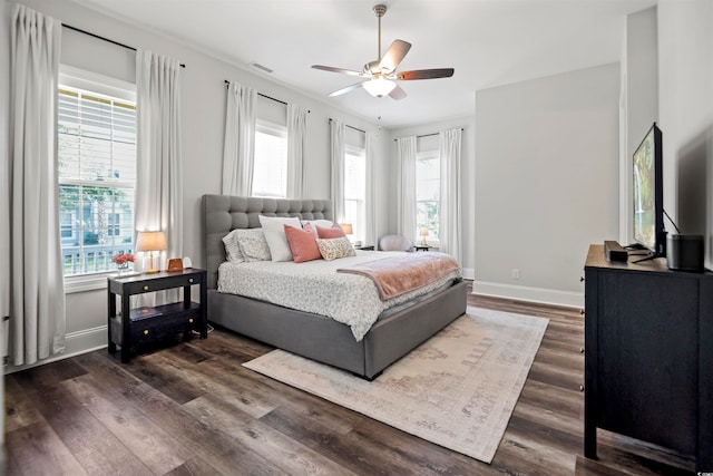 bedroom with dark wood-type flooring, ceiling fan, and multiple windows