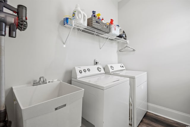 washroom featuring dark wood-type flooring, sink, and washing machine and clothes dryer