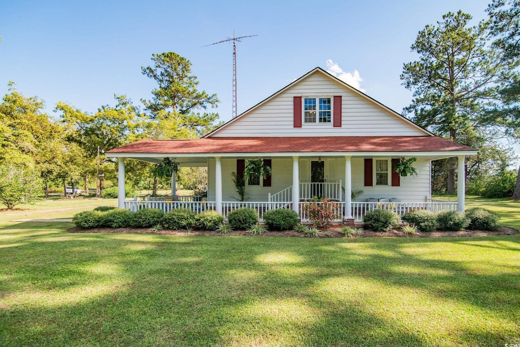 farmhouse featuring a front yard and a porch