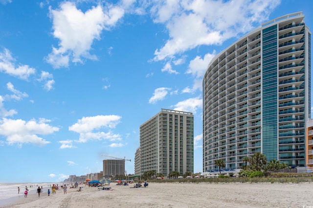 view of property with a water view and a beach view