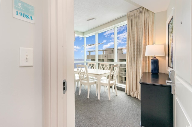 dining area featuring a textured ceiling and carpet flooring