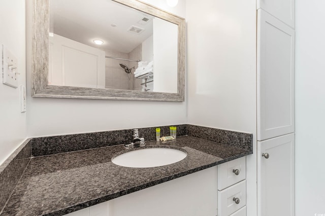 bathroom featuring vanity and a tile shower