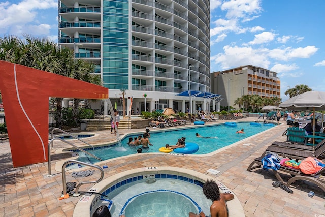 view of swimming pool featuring a community hot tub and a patio area