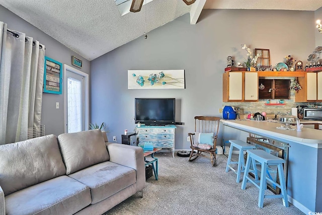 living room with vaulted ceiling with beams, a textured ceiling, light colored carpet, and ceiling fan