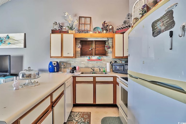 kitchen with white cabinetry, sink, white appliances, and tasteful backsplash