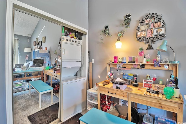 interior space with a textured ceiling and stacked washer / drying machine