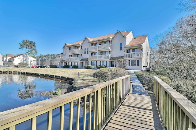 rear view of property featuring a balcony and a water view