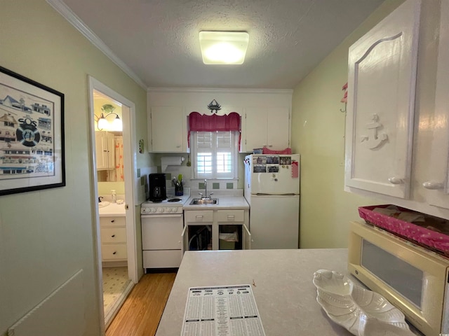 kitchen featuring light hardwood / wood-style floors, white appliances, white cabinetry, and sink