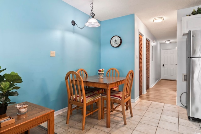 dining space featuring a textured ceiling and light wood-type flooring