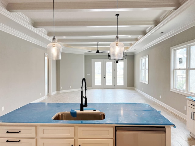 kitchen featuring sink, beamed ceiling, ornamental molding, light hardwood / wood-style flooring, and a center island with sink