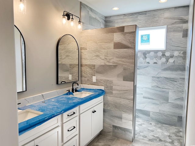 bathroom with tile walls, vanity, and a tile shower