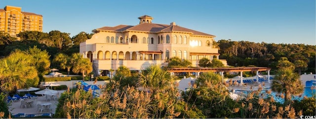 rear view of property featuring a community pool and a balcony