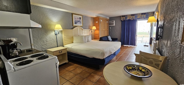 bedroom featuring access to exterior, sink, a wall mounted air conditioner, a textured ceiling, and dark tile patterned flooring