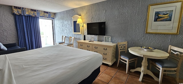 bedroom featuring dark tile patterned flooring and a textured ceiling