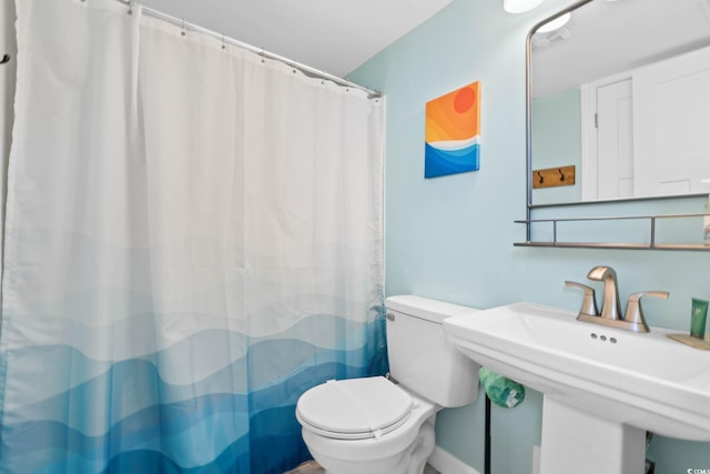 bathroom with a sink, a shower with curtain, and toilet